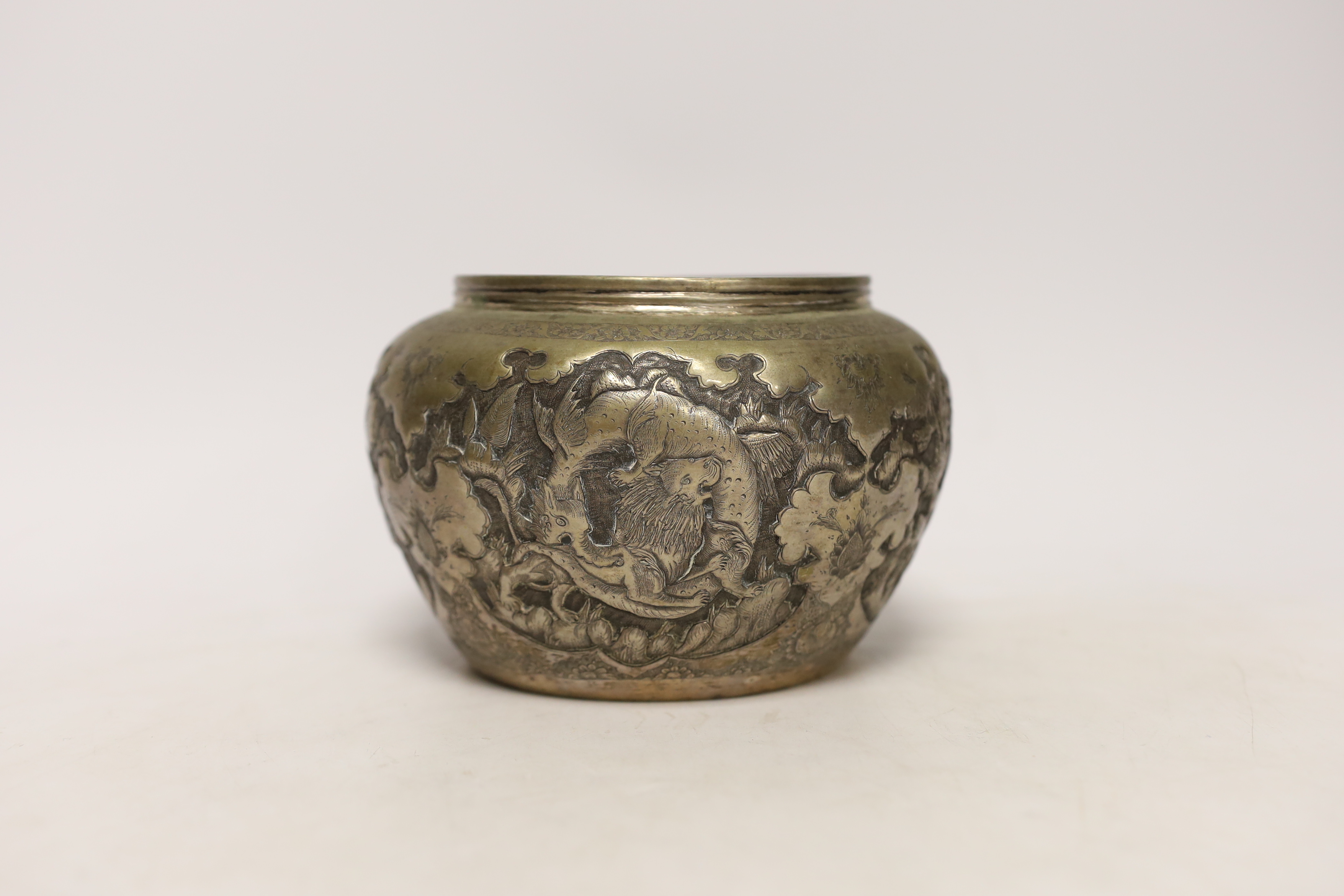 A Persian white metal bowl decorated in relief with animals and flowers, indistinct marks to the - Image 3 of 5