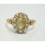 A yellow metal, cat's eye chrysoberyl and diamond cluster set ring, size L, gross weight 2.9 grams.