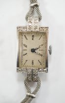 A lady's white metal and diamond set rectangular dial manual wind cocktail watch, on a 9ct white