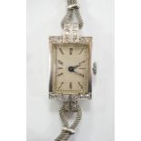 A lady's white metal and diamond set rectangular dial manual wind cocktail watch, on a 9ct white