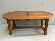 A contemporary oval oak extending dining table, 270cm extended, two spare leaves, depth 110cm,