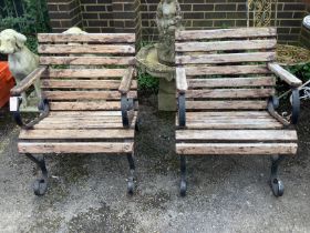 A pair of slatted wrought iron garden elbow chairs, width 61cm, height 79cm