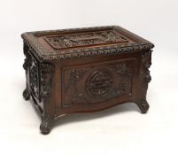 An early 20th century Chinese hongmu wood casket with removable lid and figurative heads on each