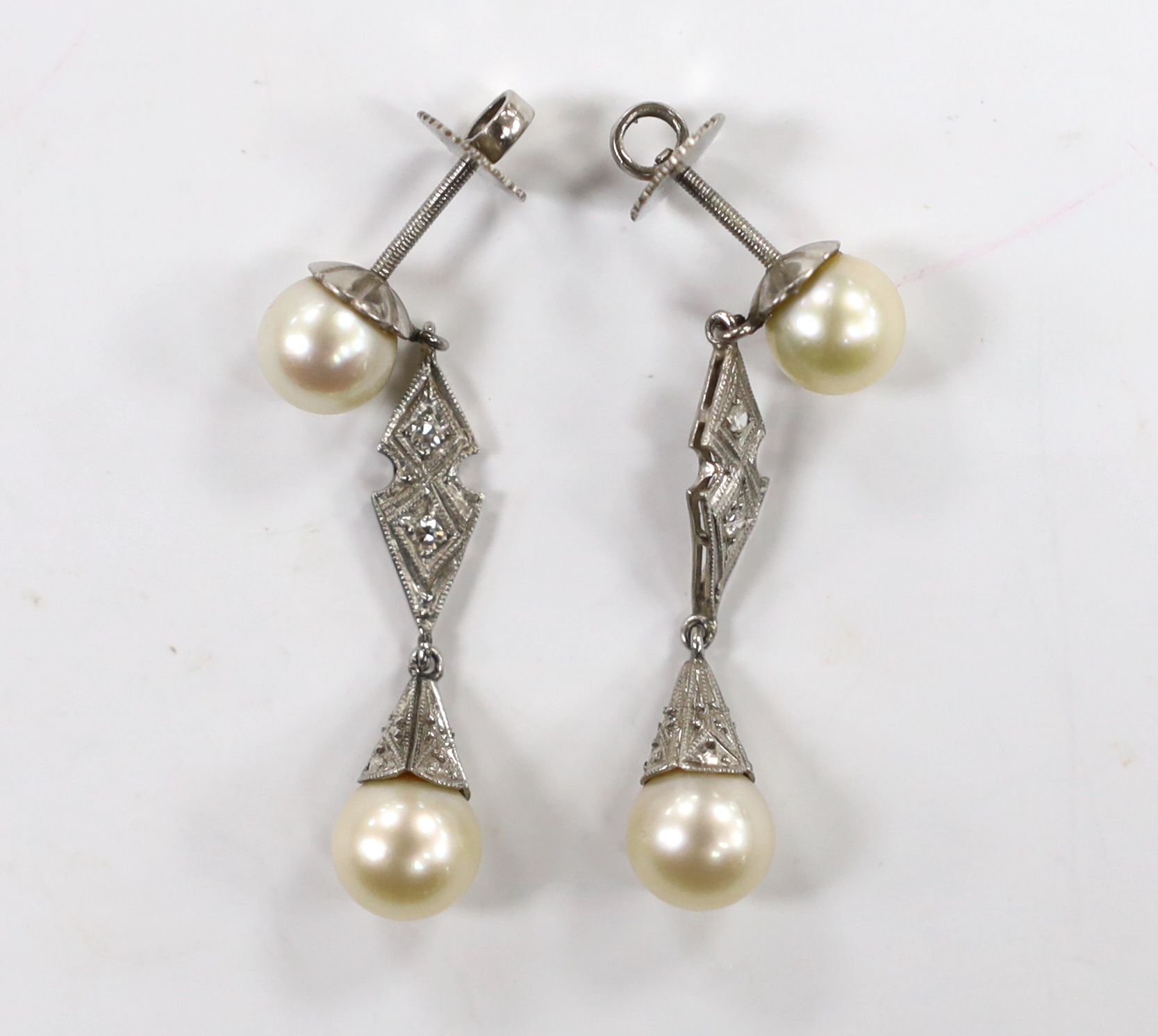 A pair of white metal, two stone cultured pearl and two stone diamond chip set drop earrings,