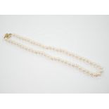 A single strand cultured pearl necklace with 18K and diamond chip set spherical clasp, 49cm.