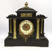 A black slate mantel clock with gilded pillars, striking on a coiled gong, 41cm high