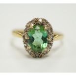 A modern 18ct gold, green tourmaline and diamond set oval cluster ring, size O/P, gross weight 3.5