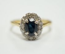 An 18ct, sapphire and diamond set oval cluster ring, size L, gross weight 2.5 grams.