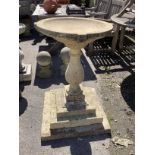 A circular stone baluster bird bath on stepped square base, height 87cm