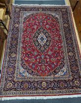 A Tabriz burgundy ground carpet, 292 x 216cm