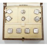 A 9ct white metal, mother of pearl and seed pearl set eight piece dress stud set, in fitted gilt