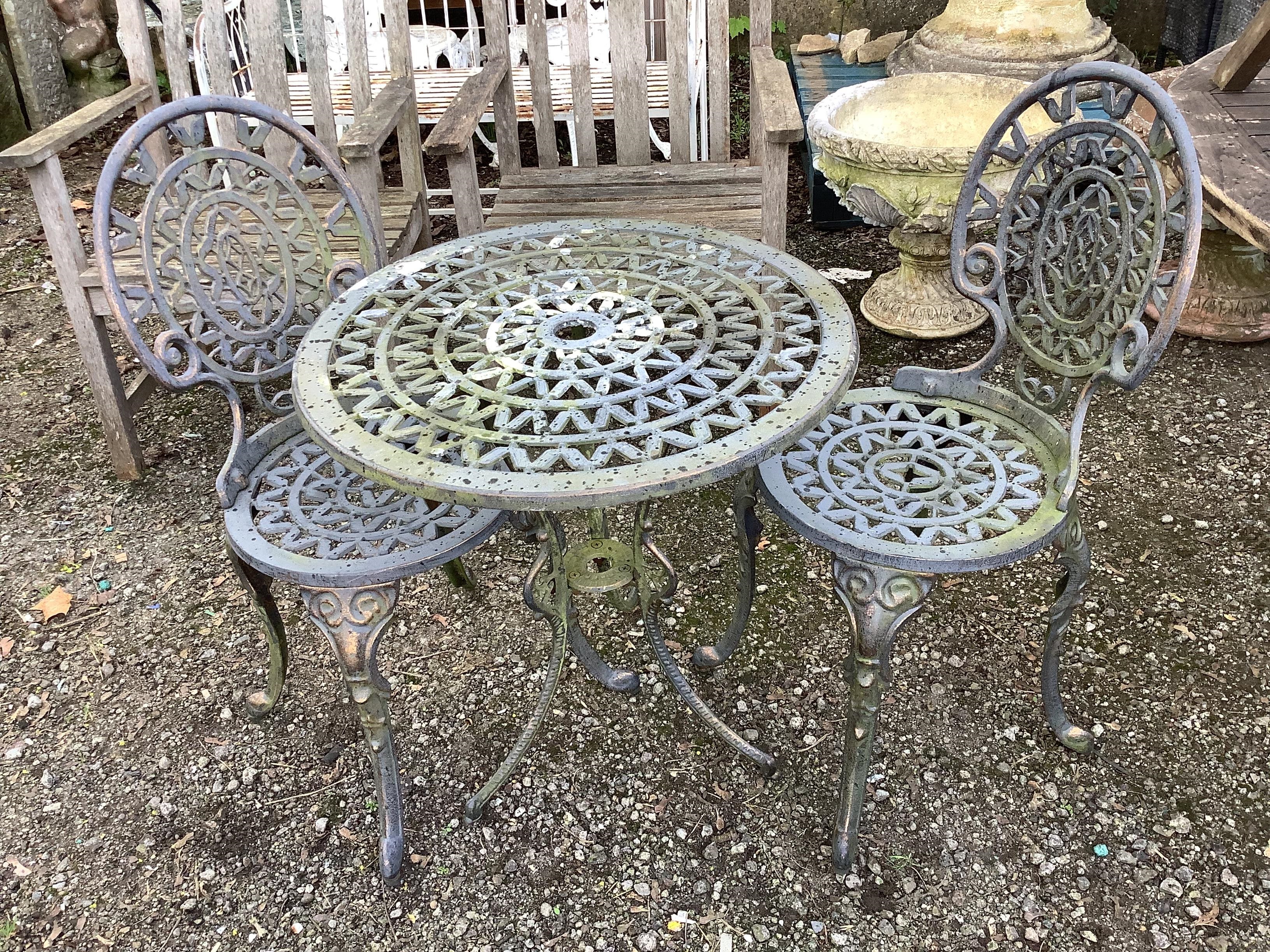 A Victorian style aluminium circular garden table, diameter 62cm, height 63cm and two chairs