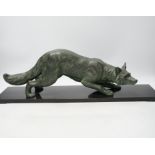 A bronzed metal model of a stalking fox, on black marble plinth, 62cm