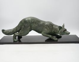 A bronzed metal model of a stalking fox, on black marble plinth, 62cm