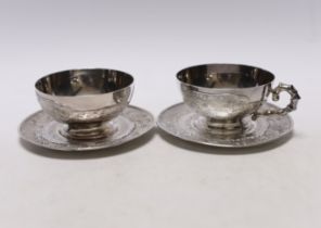 Two early 20th century Vietnamese 800 standard white metal tea cups and saucers (one lacking