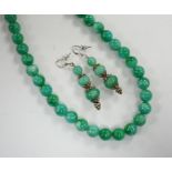 A single strand jadeite bead necklace, 41cm and a pair of jadeite earrings, stamped 18k.