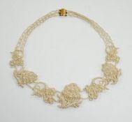 A cased Regency twin strand seed pearl choker necklace with scrolling floral motifs and yellow metal