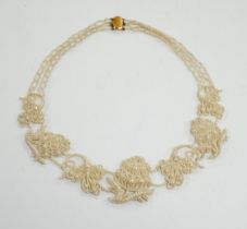 A cased Regency twin strand seed pearl choker necklace with scrolling floral motifs and yellow metal