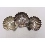 A set of three George III silver butter shells, each with engraved crest and on two shell feet, by