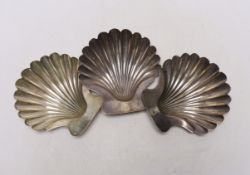 A set of three George III silver butter shells, each with engraved crest and on two shell feet, by