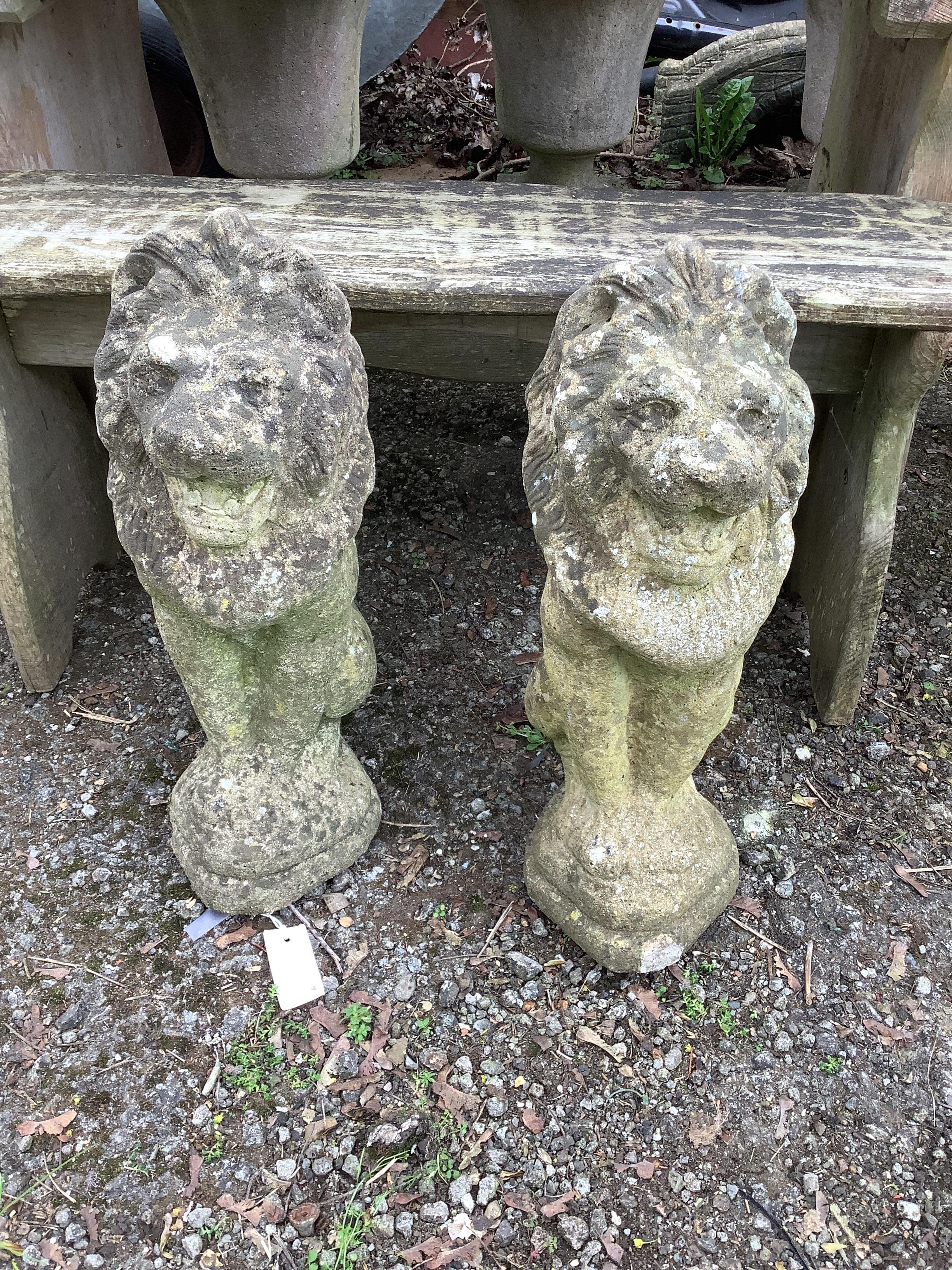 A pair of reconstituted stone seated lion garden ornaments, height 53cm