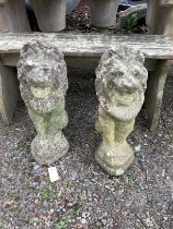 A pair of reconstituted stone seated lion garden ornaments, height 53cm