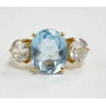 A modern 18ct gold, single stone oval cut aquamarine and two stone round brilliant cut diamond set