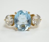 A modern 18ct gold, single stone oval cut aquamarine and two stone round brilliant cut diamond set