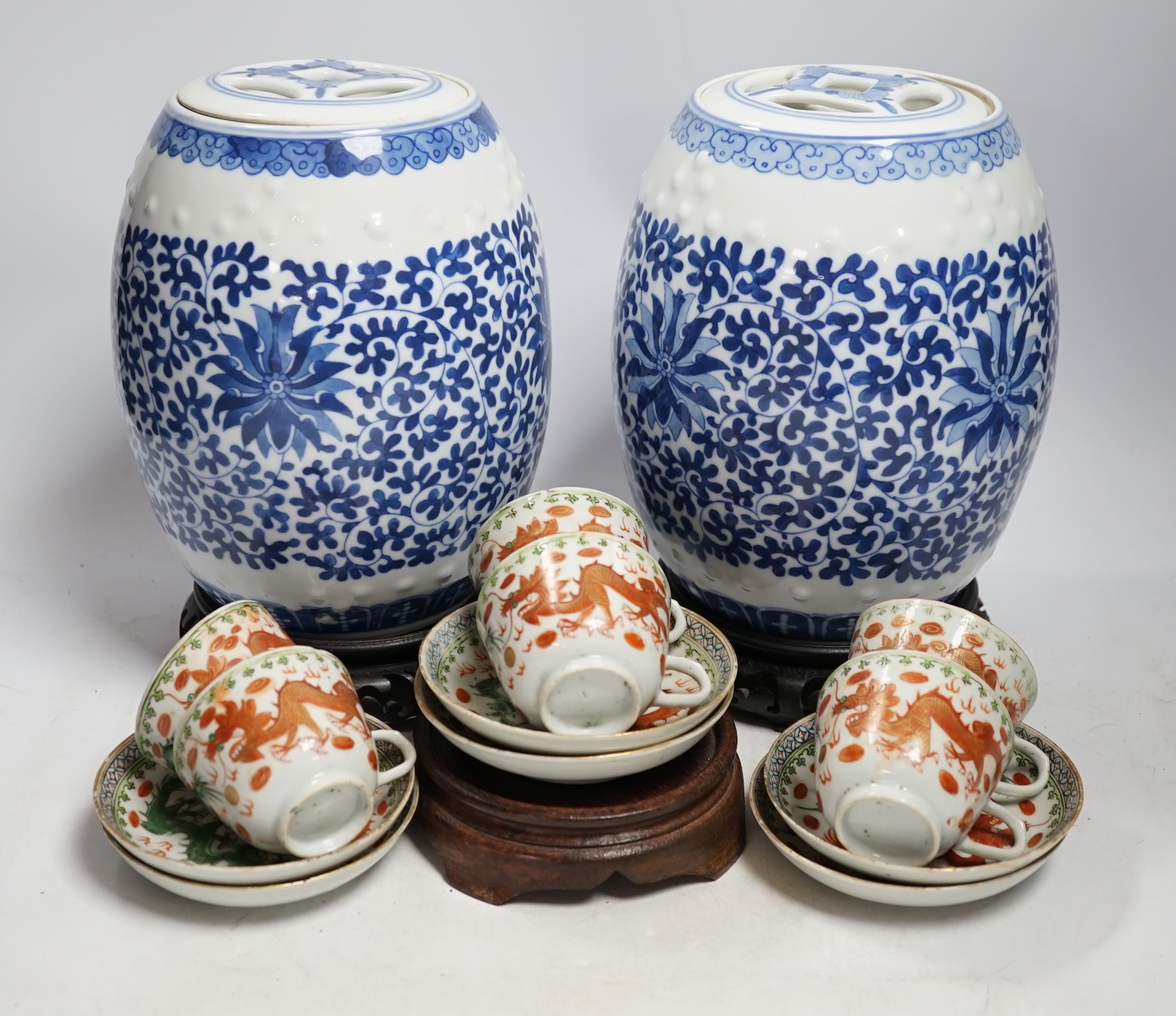 A pair of Chinese blue and white barrel jars, various cups and saucers and three hardwood stands,