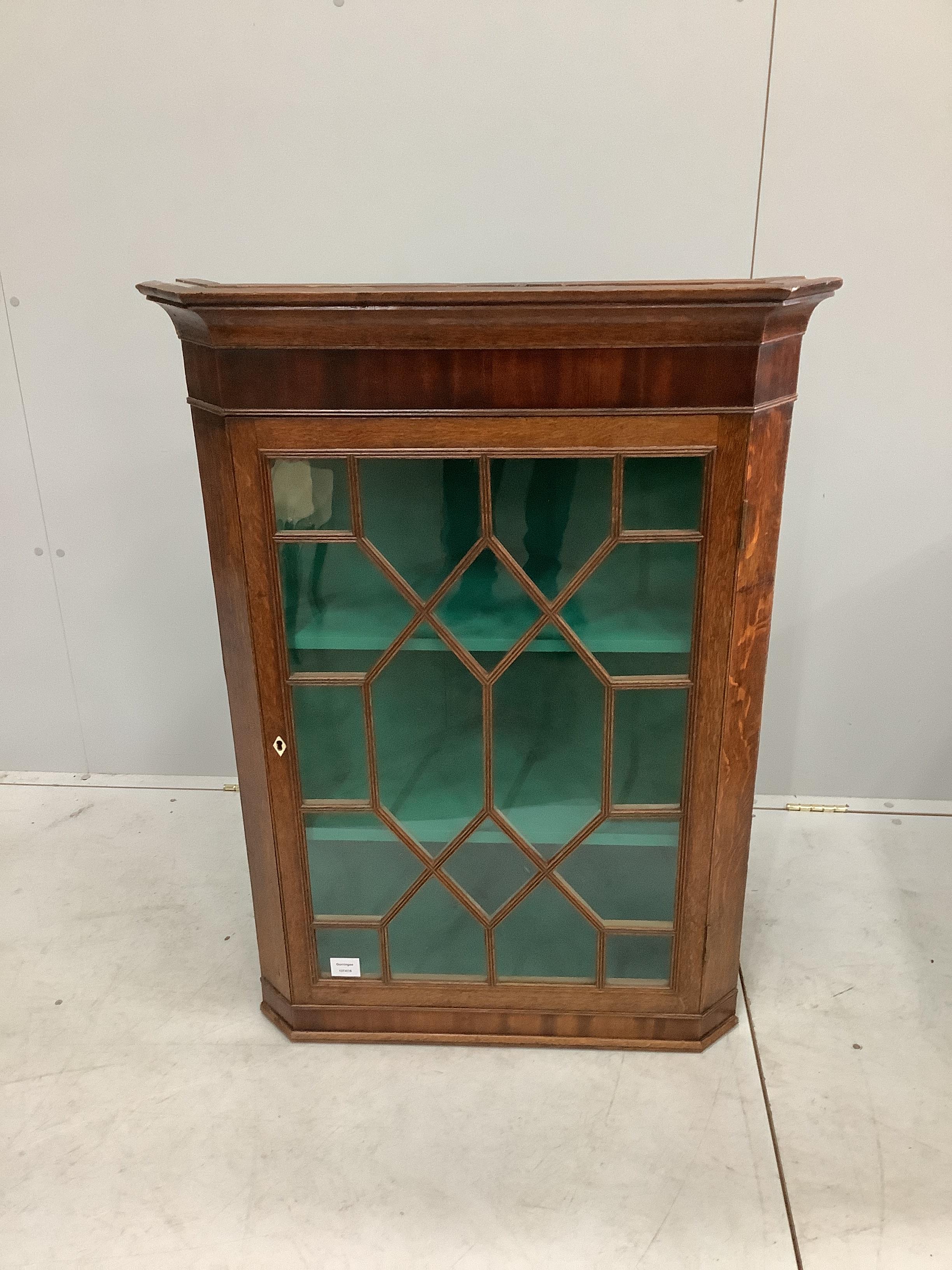 A George III oak and mahogany hanging corner cupboard, width 74cm, depth 44cm, height 103cm