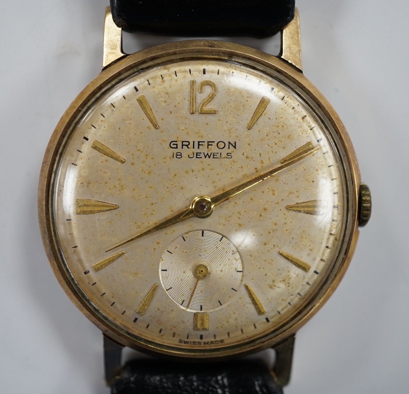 A gentleman's Swiss 9ct gold Griffon manual wind wrist watch, on a leather strap.