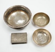 A Tibetan white metal mounted cup, two coin inset dishes and a silver matchbox holder, largest 11.