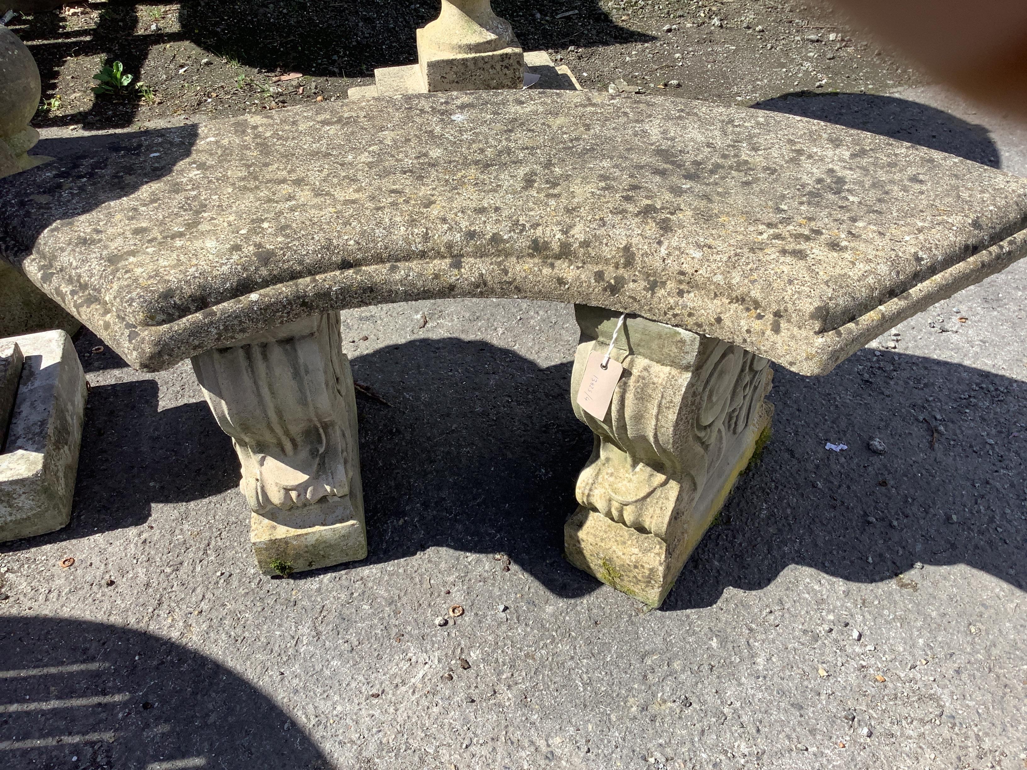 A reconstituted stone curved garden seat, width 106cm, depth 46cm, height 44cm