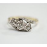 A mid to late 20th century 18ct gold and illusion set three stone diamond crossover ring, size N,
