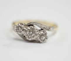 A mid to late 20th century 18ct gold and illusion set three stone diamond crossover ring, size N,