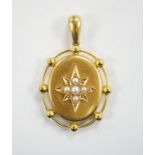 A Victorian yellow metal and split pearl set oval pendant, the glazed back with painted monogram
