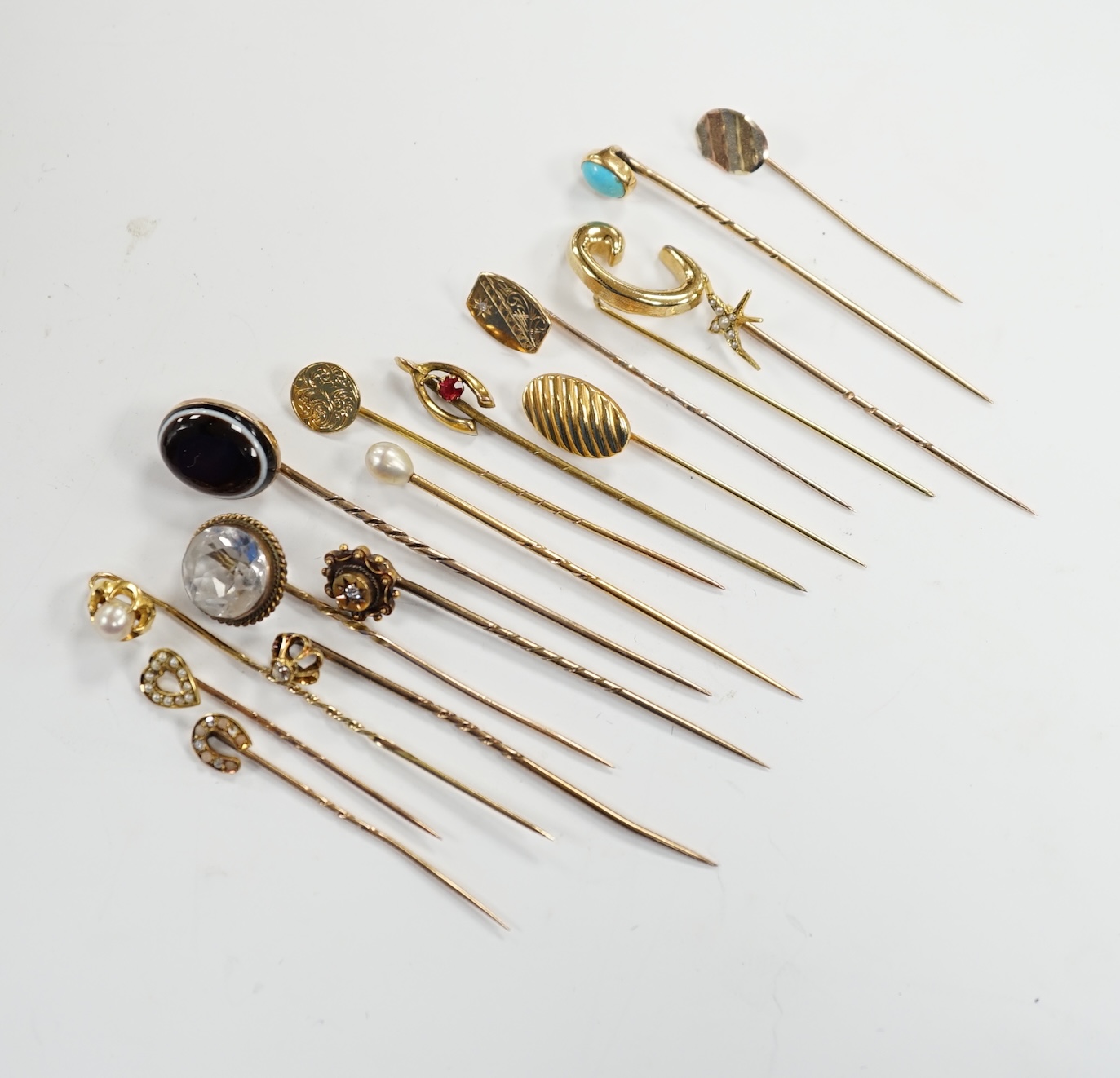 Fifteen assorted mainly early 20th century yellow metal and gem set stick pins, including diamond,