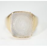 An early 20th century yellow metal and white chalcedony intaglio ring, the matrix carved with the