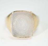 An early 20th century yellow metal and white chalcedony intaglio ring, the matrix carved with the