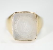 An early 20th century yellow metal and white chalcedony intaglio ring, the matrix carved with the