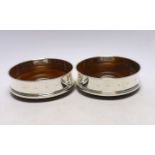 A pair of Elizabeth II silver mounted wine coasters, with turned wooden bases, Roberts & Dore,