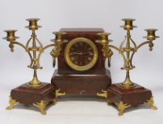 A late 19th century French rouge marble and ormolu clock garniture, 31cm