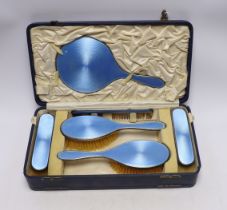 A cased George V silver and blue guilloche enamel mounted six piece mirror and brush set, Charles