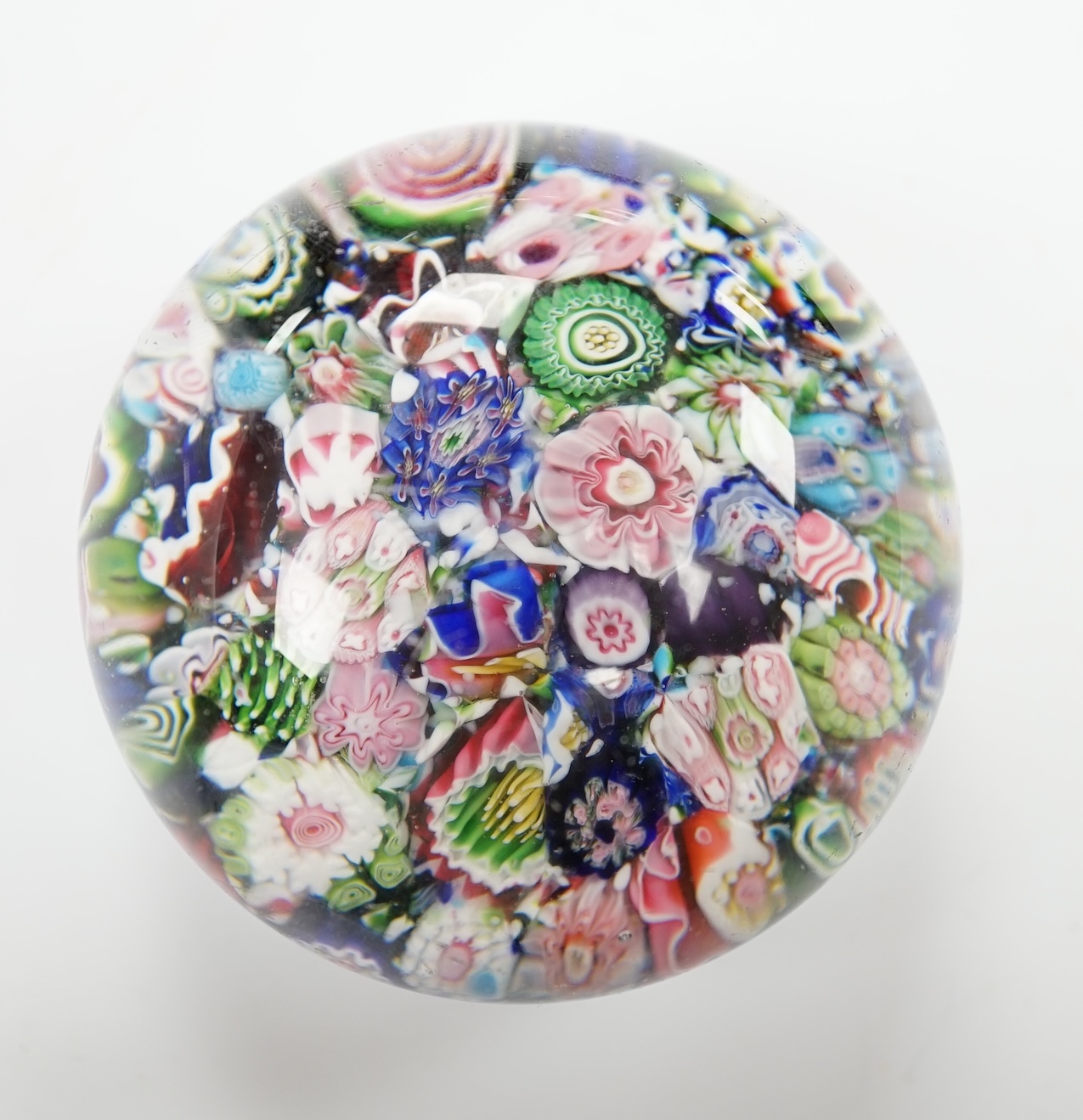 A Clichy scrambled glass paperweight with unusual pink and green rose, 6.5cm in diameter