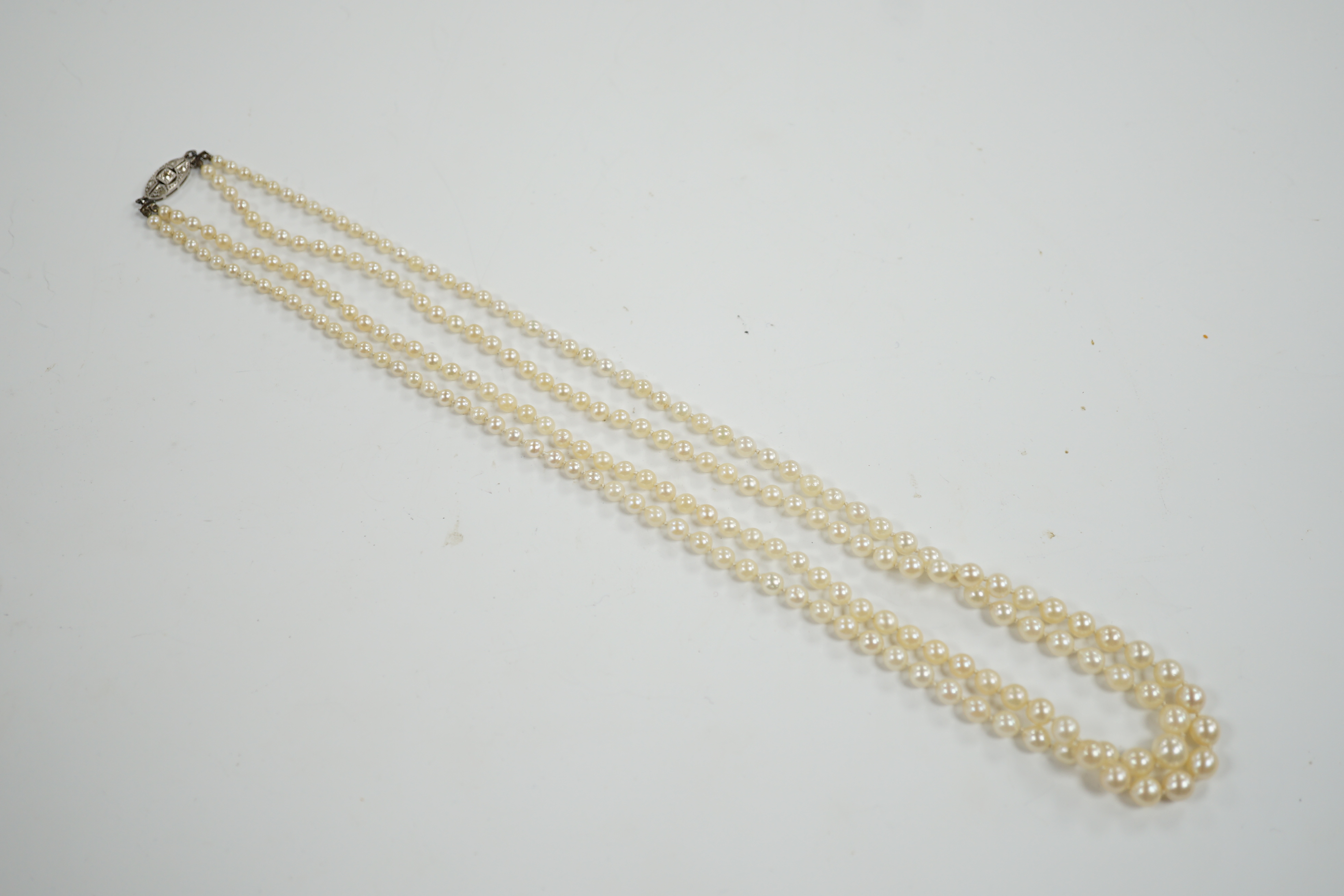 A 1930's twin strand graduated cultured pearl necklace, with 14ct, plat and diamond chip set - Image 2 of 4