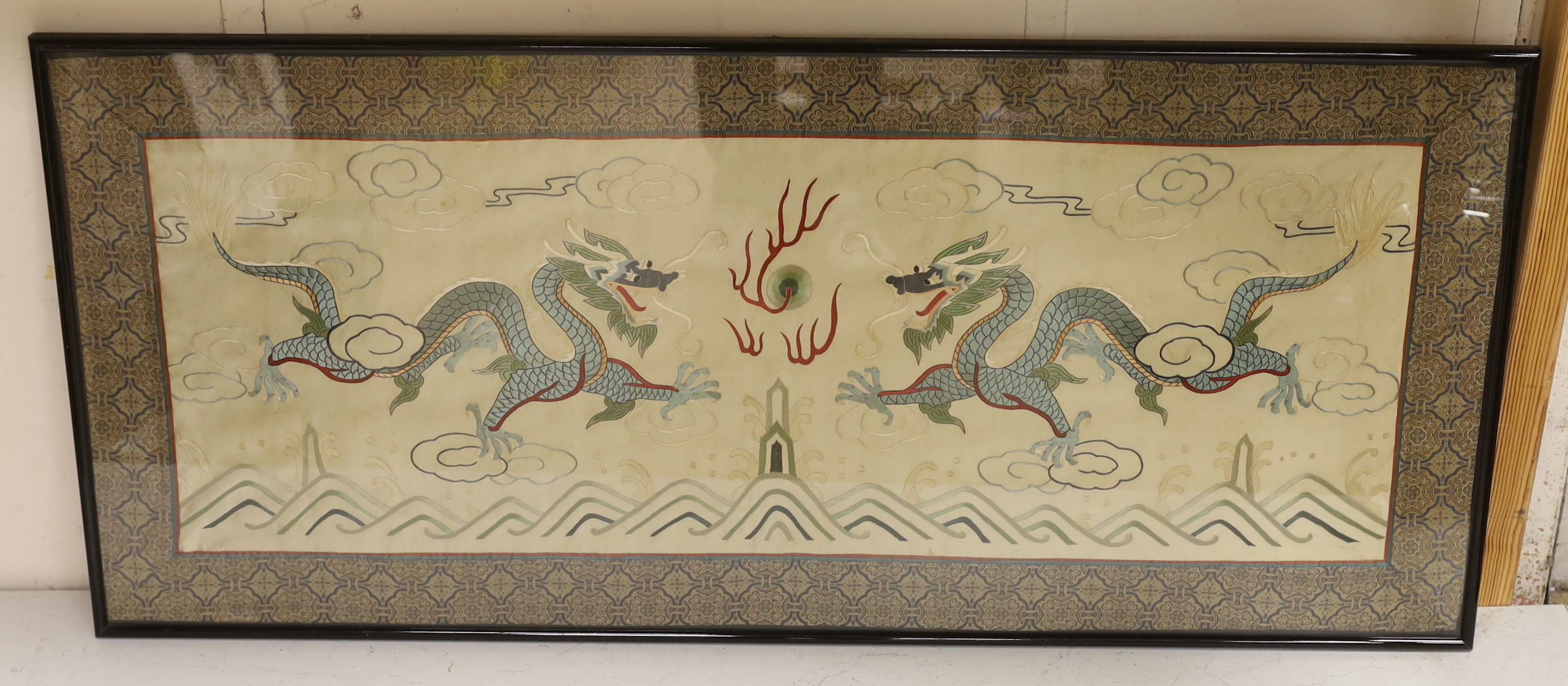 A framed 20th century Chinese silk embroidered 'dragon’ panel, with flaming pearl design, bordered