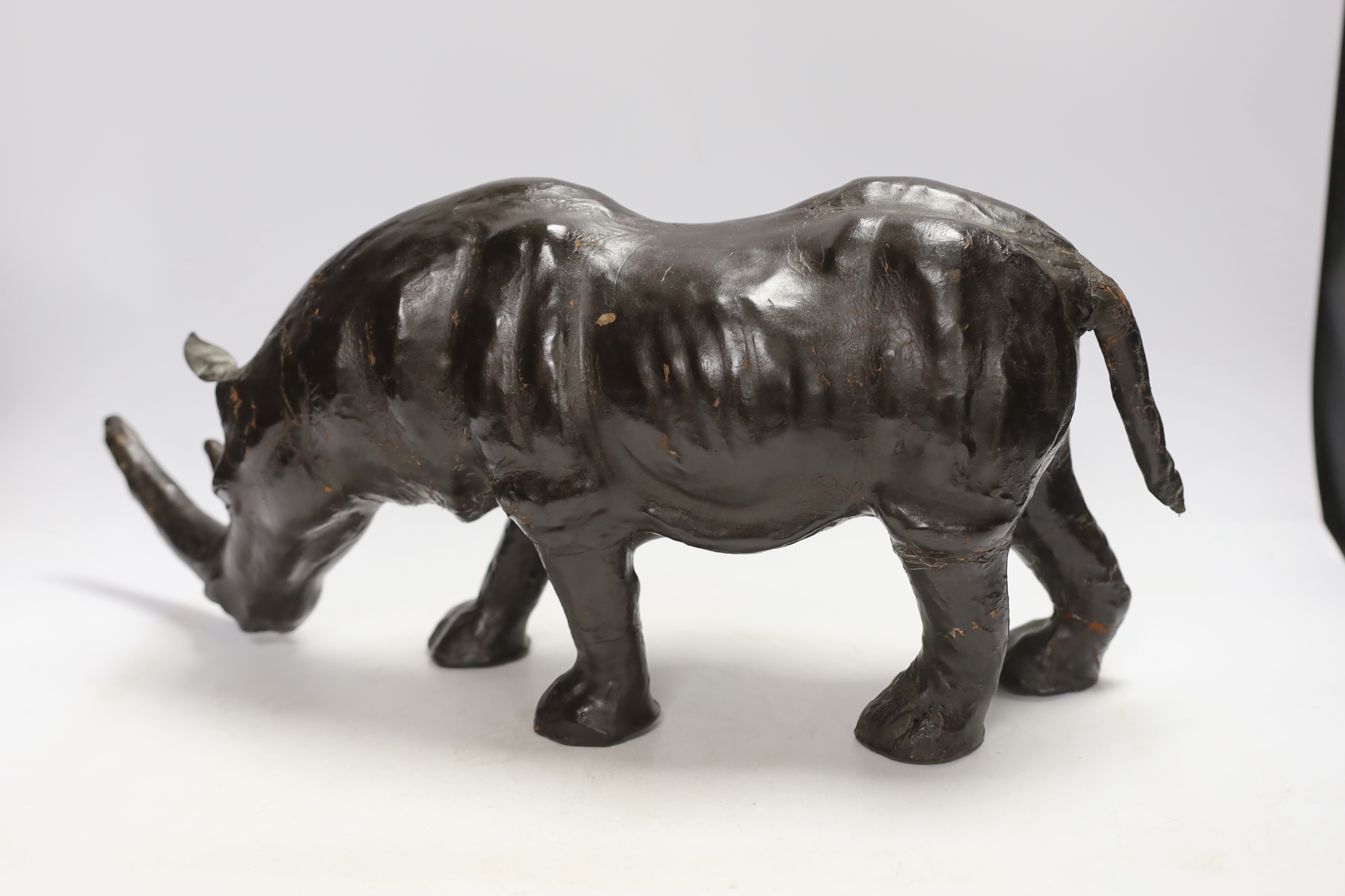 A leather rhinoceros figure with glass eyes, stamped Liberty to the underside, 54cm wide - Image 2 of 4