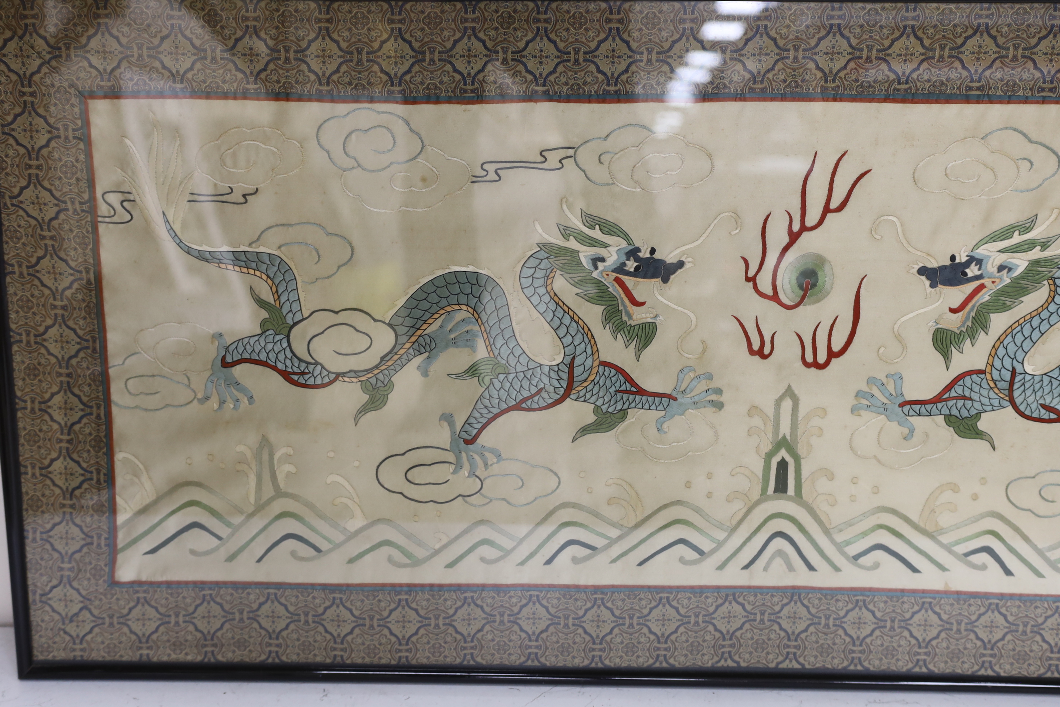 A framed 20th century Chinese silk embroidered 'dragon’ panel, with flaming pearl design, bordered - Image 2 of 3