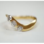 A modern 750 yellow metal and three stone diamond set crossover ring, size P, gross weight 5.4