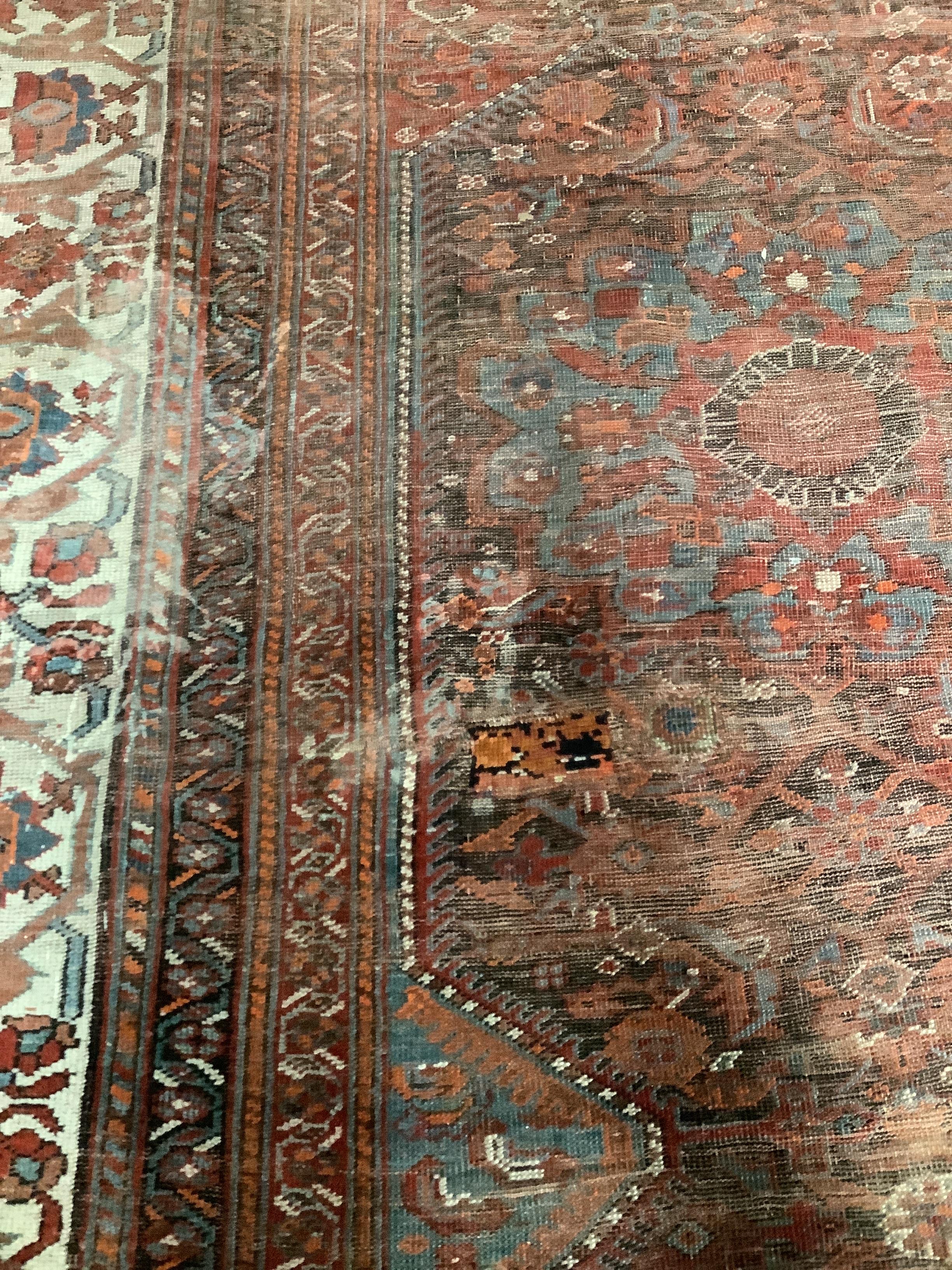 An early 20th century North West Persian red ground carpet, 410 x 348cm, worn and patch repaired. - Image 3 of 4